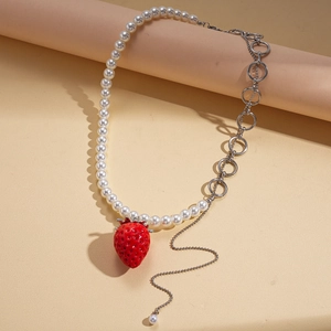 Detailed macro view of asymmetric pearl chain with realistic red strawberry pendant