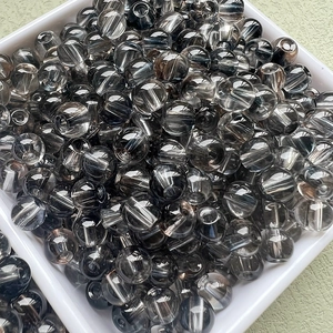 Vue macro de perles en verre gris foncé translucide 6mm pour bijoux DIY