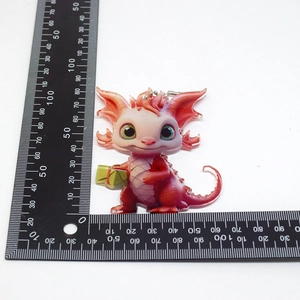 Size measurement of a cartoon red dragon acrylic ornament with a green gift box