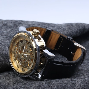 Detailed close-up of golden skeleton watch dial showing mechanical movement on grey felt
