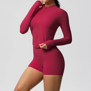 Detail of burgundy fitness set featuring thumbhole zip jacket and high-waist yoga shorts