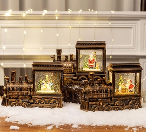 Three bronze Christmas train lanterns with glowing snow globe scenes on a cozy mantle