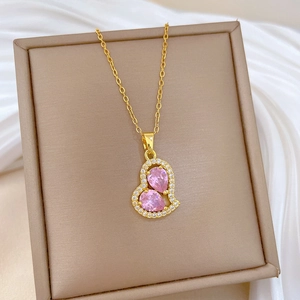 Elegant gold titanium necklace featuring a pink heart pendant with sparkling pavé crystals