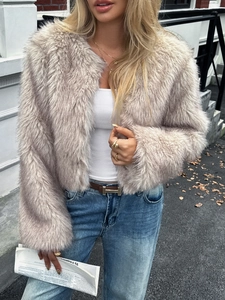 Detail of greyish beige long sleeve faux fur jacket worn in an outdoor street setting