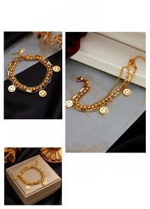 Detail of double-layer gold beaded chain bracelet featuring classic smiley face pendants