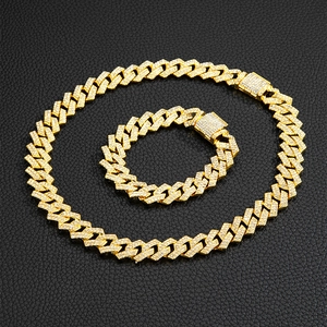 Détail du collier et bracelet gourmette dorés avec strass sur fond de cuir noir luxueux