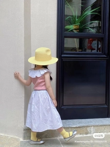 Outfit estivo da bambina con top rosa, gonna a righe, cappello di paglia e Mary Jane argento