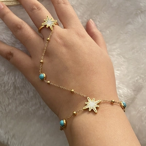 Vue détaillée du bracelet bague doré avec turquoise et pendentif étoile sur velours