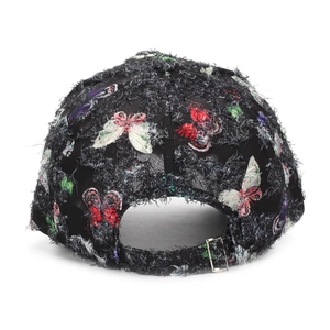 Detail der schwarzen Baseballkappe im Distressed-Look mit bunten Schmetterlingsdrucken