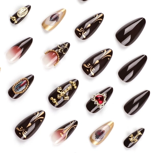 Press-on nails featuring embossed golden crosses and heart gems in dark red and black tones
