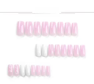 Detail of pink gradient and white press-on nails with minimalist heart patterns