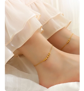 Detail of elegant gold beaded anklet in 18K gold plated steel worn by a model