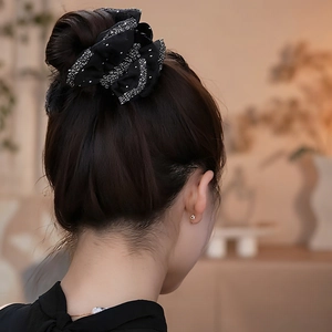 Chouchou élégant en organza noir à pois blancs sur une coiffure en chignon chic
