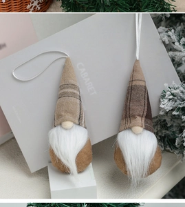 Nahaufnahme von Weihnachts-Wichteln mit braunen Karo-Hüten und Bärten an Tannenzweigen