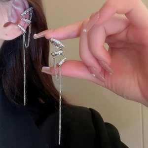Detail of silver tassel ear cuff with sparkling zircons and long metal fringe chains