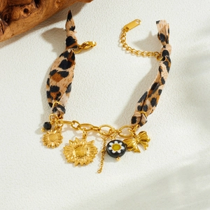 Gold chain bracelet with leopard print fabric sunflower and bow pendants on stone