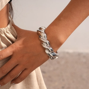 Close-up of a silver thick twisted rope texture cuff bracelet on a model wrist