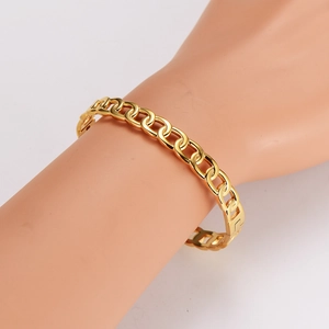 Polished gold stainless steel link bracelet for women worn on a model's wrist