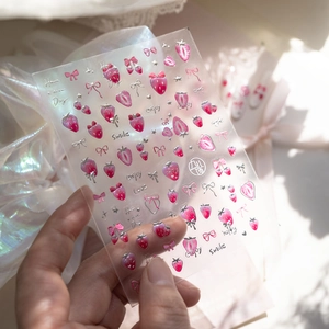 Detail of pink strawberry nail art stickers with embossed bows and silver stars