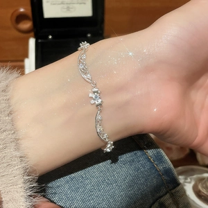 Close-up of zircon heart silver bracelet featuring wavy hollow lace and elegant charms