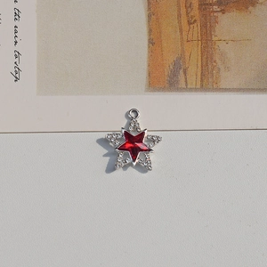 Detail of a red star charm with silver frame and crystals for DIY jewelry making