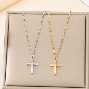 Detail of silver and gold cross necklaces with white zircon stones on display tray