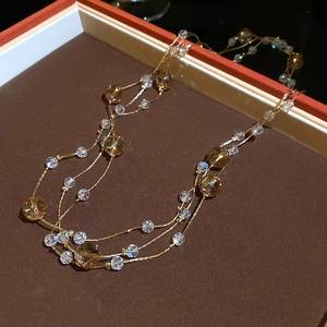 Detailed close-up of multilayered crystal beads and gold chain in a display case