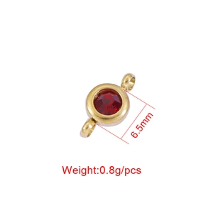 Macro shot of 6.5mm gold stainless steel birthstone charm with a red faceted crystal