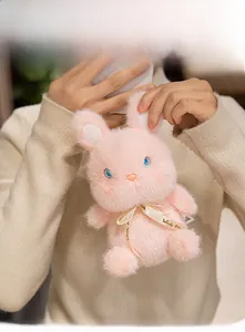 Soft pink plush bunny with long ears and Woody friend ribbon shown in hands