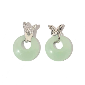 Detalle de pendientes de jade con mariposa plateada y circones sobre fondo blanco