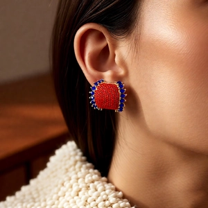 Detail of luxury vintage C-shaped earrings with red clusters and blue teardrop stones