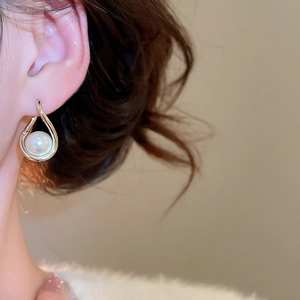 Détail de boucles d'oreilles gouttes argentées avec perles sur mannequin femme
