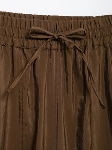 Detail of satin high-waisted safari trousers with elastic waistband and ribbon drawstring tie