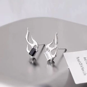 Detail view of silver flame-shaped earrings with black and white rectangular crystals