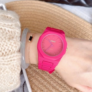 Close-up of rose red octagonal quartz watch on wrist with soft knit sweater background