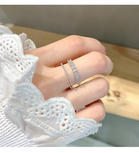 Close-up of double-layered silver ring with pavé-set zircons on hand with lace sleeve