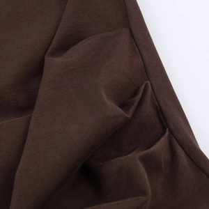 Close-up detail of dark brown ruched fabric texture on this stylish knitted dress