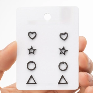 Macro view of four pairs of black matte stainless steel geometric stud earrings on card
