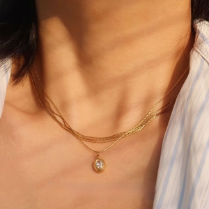Close-up of a vintage gold plated titanium steel necklace with an oval zircon pendant
