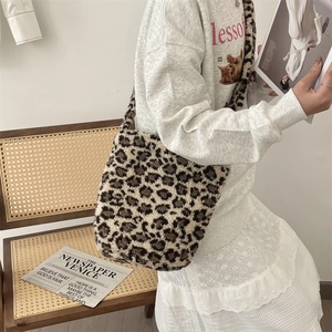 Detail of trendy leopard print plush tote bag worn by a model in a cozy interior