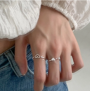 Close-up of adjustable silver bow heart rings with sparkling crystals on a hand
