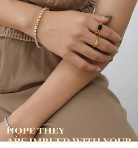 Close-up of 18K gold plated tennis bracelet and zircon ring set styled on wrist
