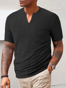 Close-up of black waffle knit fabric texture on men's V-neck shirt with chest pocket