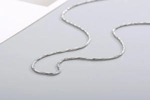 Macro close-up showing the smooth texture of a polished silver stainless steel snake chain