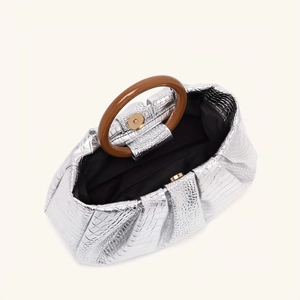 Top view of silver crocodile texture clutch bag with resin ring handle and magnetic closure