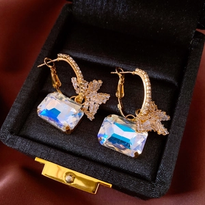 Detail of luxury gold earrings with AB color crystal pendants and star accents