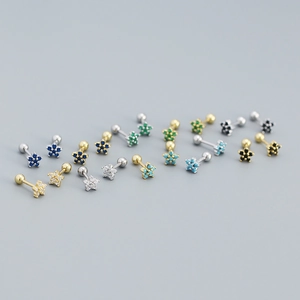 Macro view of floral zircon earrings in gold and silver with multi-color crystal inlay