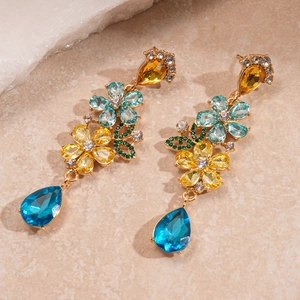 Detailed close-up of vintage floral drop earrings with multicolored crystals and blue teardrop