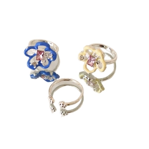 Floral enamel ring set with blue and yellow petals and pink crystals on white background