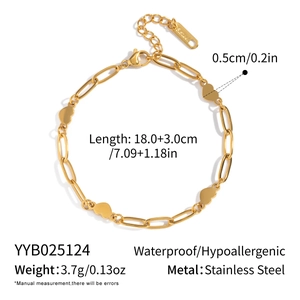 Macro detail of golden stainless steel paperclip chain bracelet with heart charm